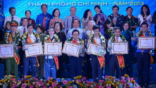 Lãnh đạo Thành phố và các đại biểu chụp ảnh lưu niệm với 7 công dân trẻ tiêu biểu (Ảnh: Quang Định/Báo Tuổi Trẻ)
